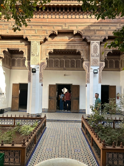       People entering a beautifully decorated Moroccan building.
  