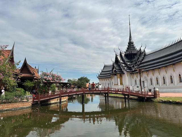       A traditional Thai architectural structure with a bridge over a pond.
  
