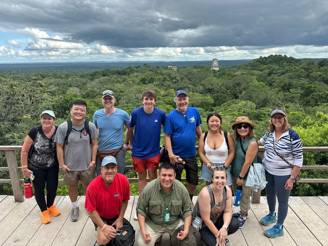 Large group posing with jungle and ancient structures.