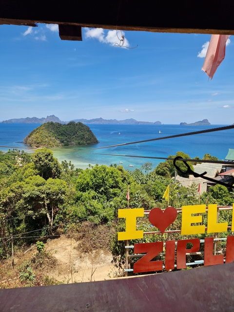       Aerial view of islands with lush greenery surrounded by blue ocean and blue sky.
  
