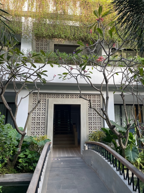       Modern building facade framed by tree branches.
  