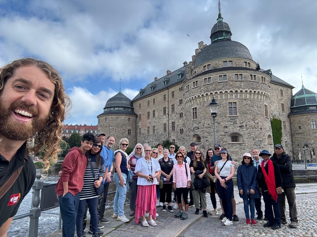       Large group in front of a castle with rounded towers.
  