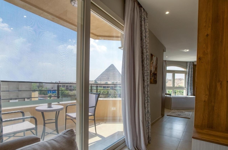 View of the pyramids from a hotel room with balcony seating.