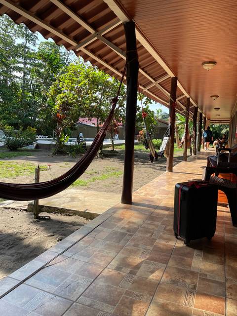 A porch with hammocks and a view of nature.