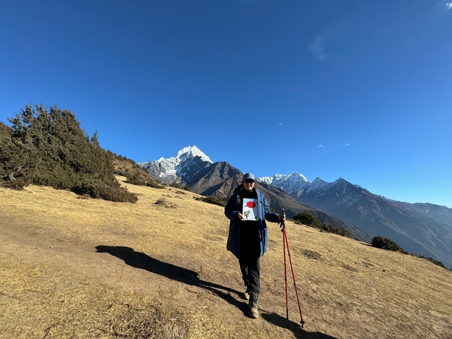       A person hiking with mountains in the background.
  