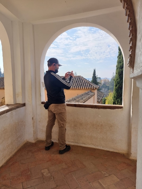 Person taking a photo from a balcony with a scenic view.