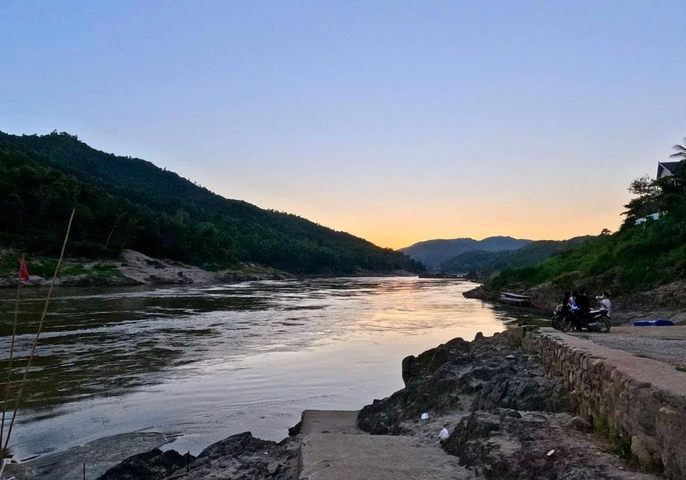 Sunset view over a river surrounded by hills.