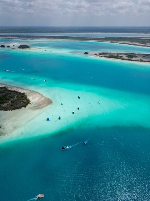 Aerial view of turquoise waters with boats.
