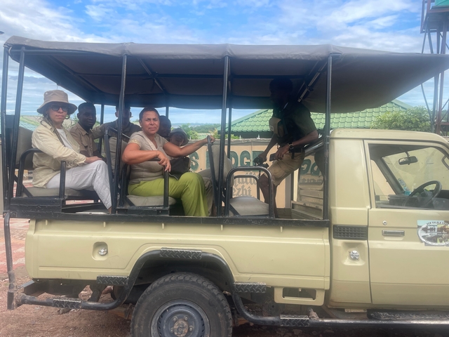       People sitting in an open safari vehicle.
  