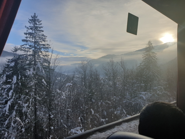       Scenic view of a snowy landscape with foggy mountains.
  