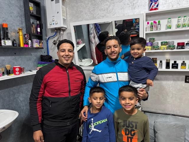 Group of people in a small barbershop.