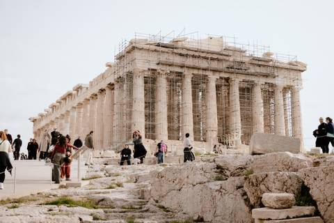 Parthenon under restoration with visitors around.