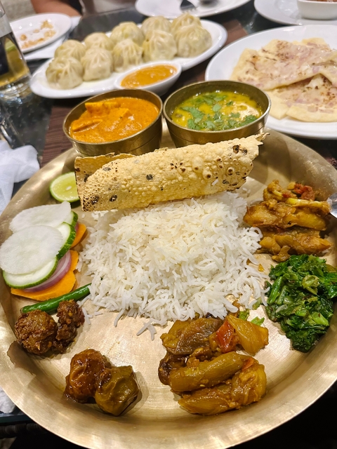      A traditional meal with rice, vegetables, and curry.
  