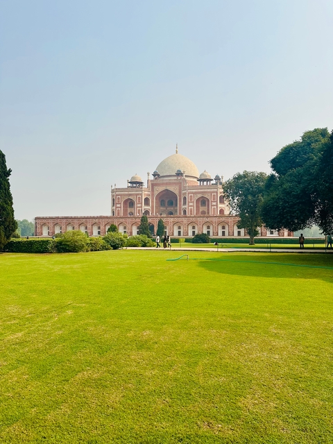 A large mausoleum with a well-maintained garden in front.