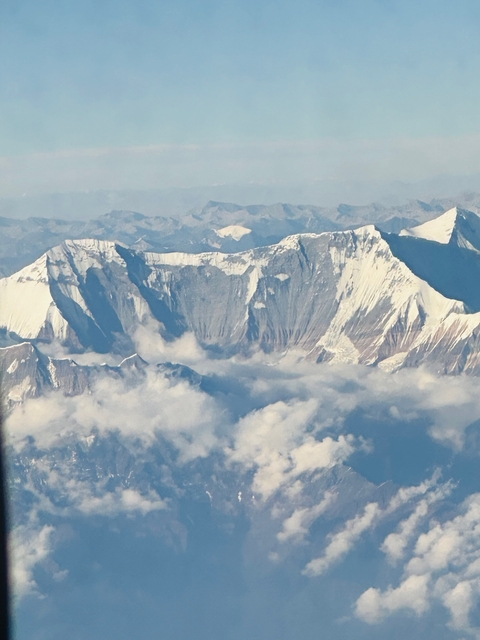 Aerial view of mountains with snow and clouds.