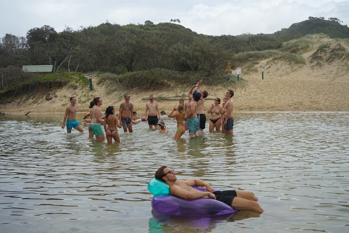 Groups of people playing in shallow water.