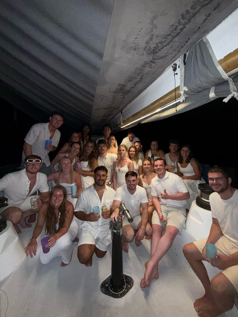       Group of people on a boat at night.
  