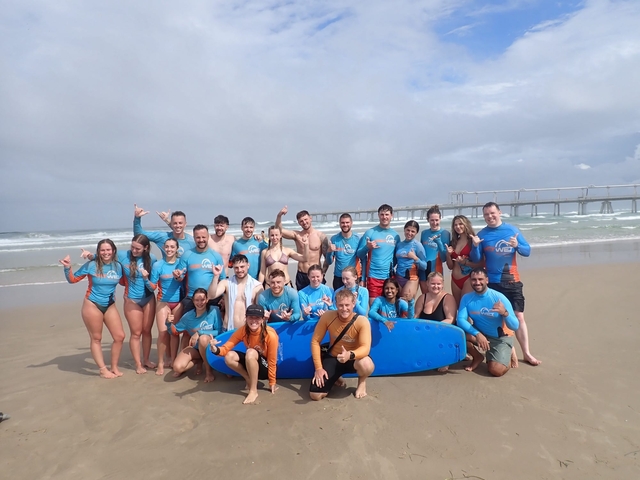People learning to surf on a beach.