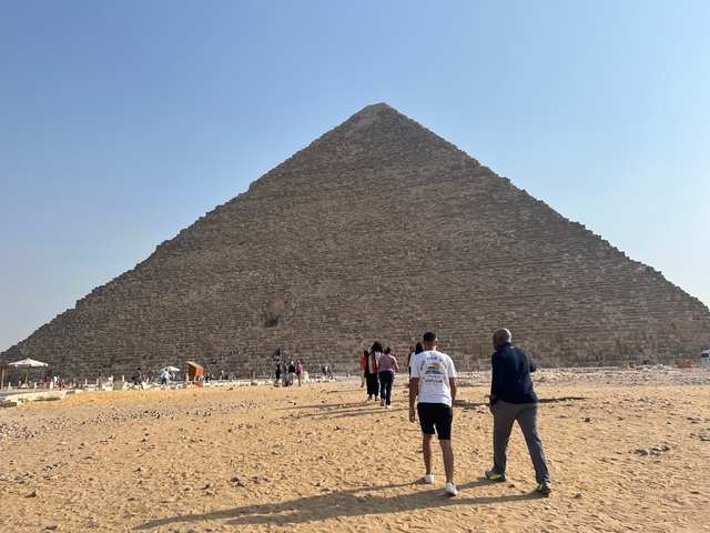       The Great Pyramid of Giza with people in foreground.
  