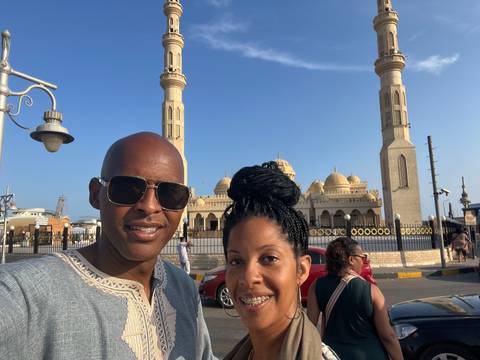       Couple posing with a mosque in the background.
  