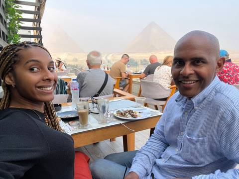       People dining with a view of the Pyramids.
  