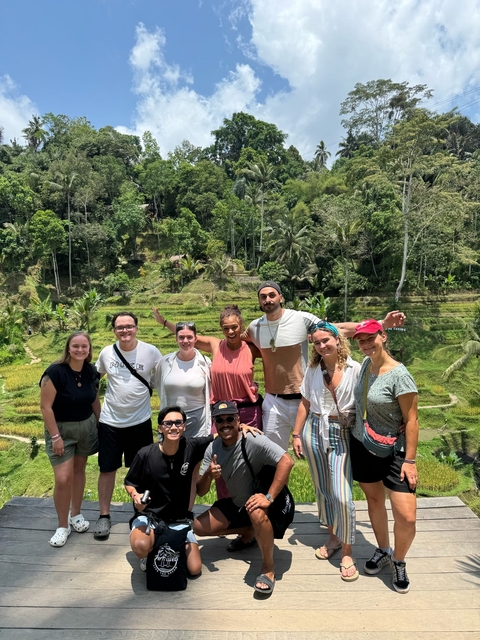 Group of people posing in front of rice terraces.