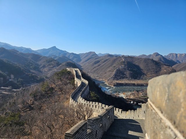 A panoramic view of the Great Wall of China extending over mountains.