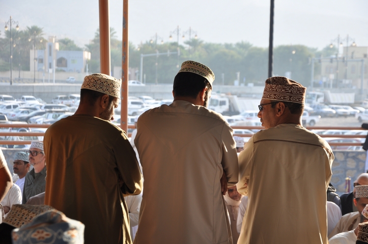 Three men in traditional clothing engaged in conversation.