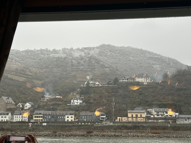 Misty hills with houses and smoke rising from chimneys.