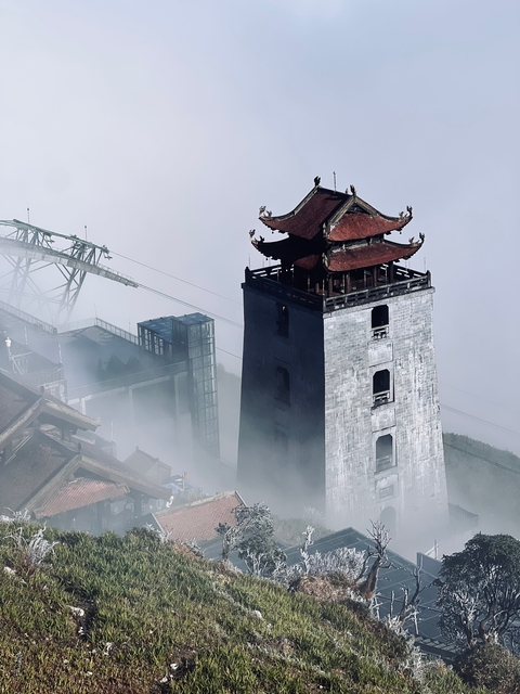       A traditional pagoda tower rising above the mist.
  