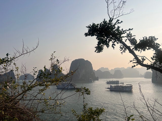       Boats sailing among limestone islands on a tranquil bay.
  