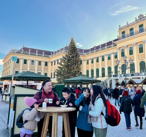 Family in front of a baroque-style building during Christmas.