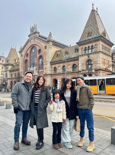 Family in front of a historic building with a tram.