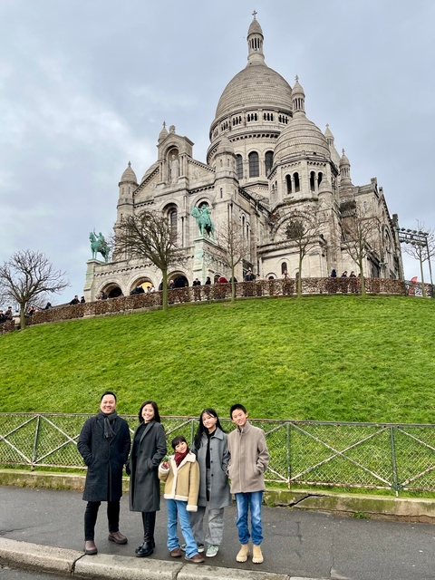 People posing in front of a historic basilica.