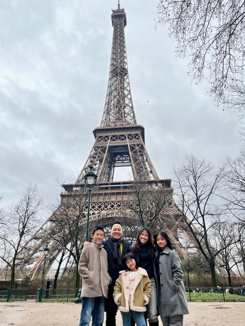       People in front of the Eiffel Tower.
  