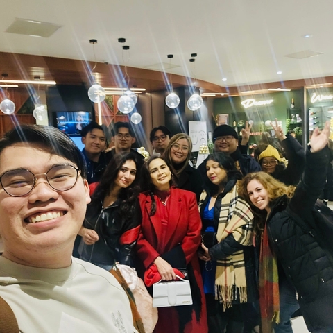 Group of people inside a store with balloons in the background.