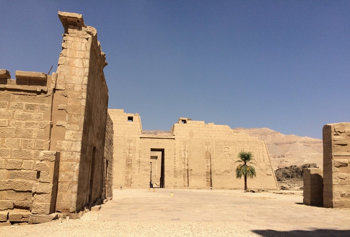 Exterior of a large ancient temple with clear blue sky.