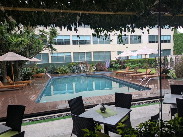 Outdoor pool with lounge chairs and umbrellas.