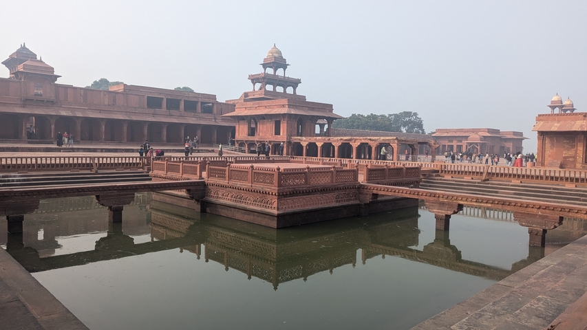       Historic site with water feature and visitors walking around.
  