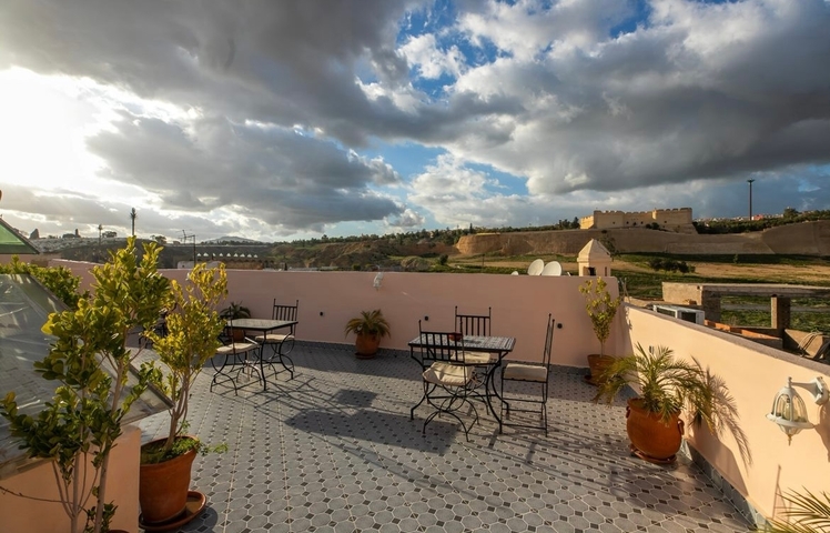       Terrace view overlooking a field and distant buildings.
  