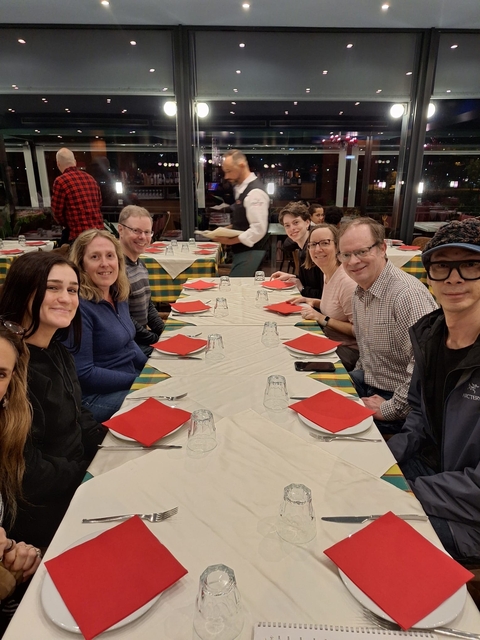       Group of people seated at a restaurant table.
  