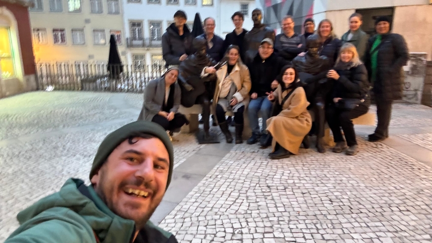       Group of people taking a selfie with a sculpture.
  