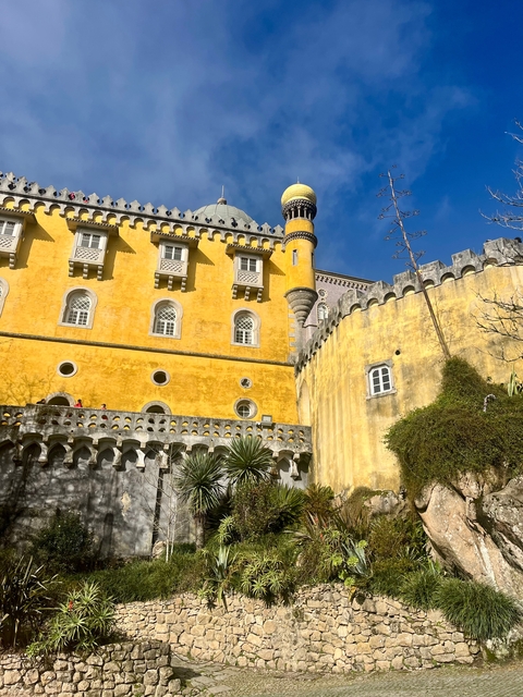       Yellow and gray palace building under a clear blue sky.
  