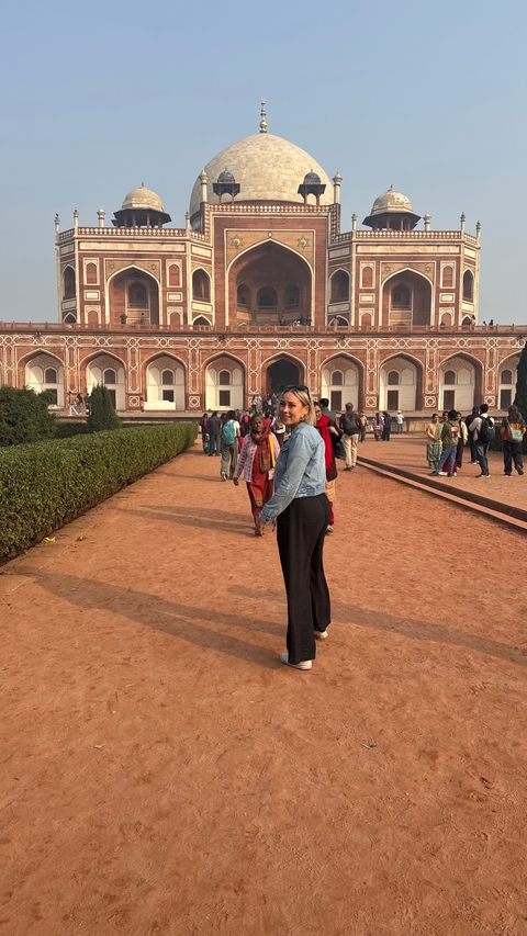       People walking around a historic site with intricate architecture.
  