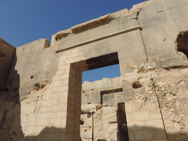 Close-up view of ancient stone ruins under a clear blue sky.