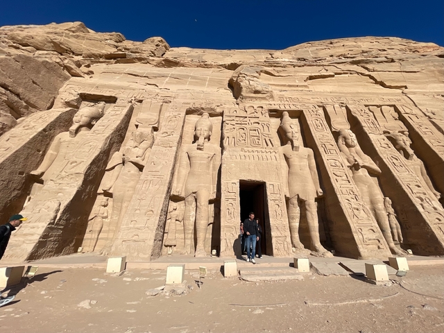 Rock carved temple facade with visitors.