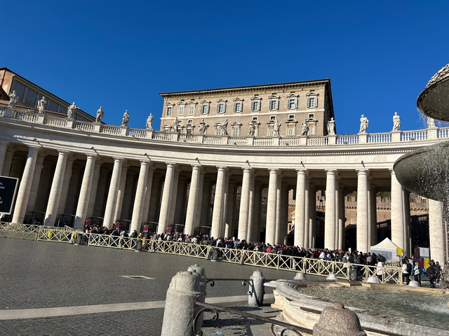Impressive architectural structure with columns and sculptures under a blue sky.