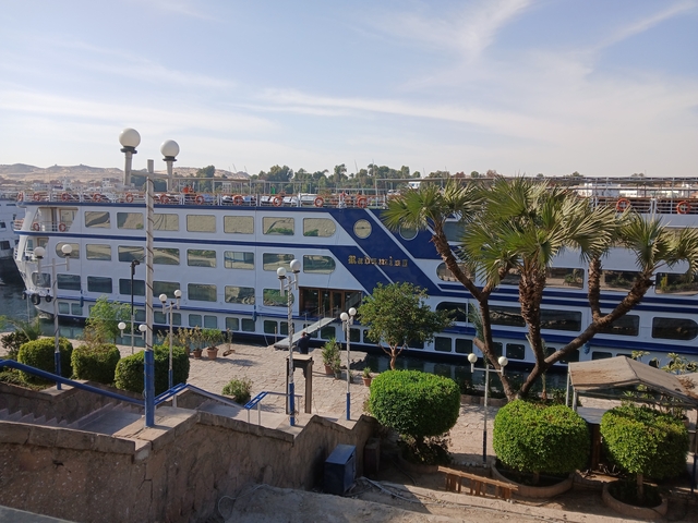 A cruise ship with lifeboats and decks visible near the Nile.