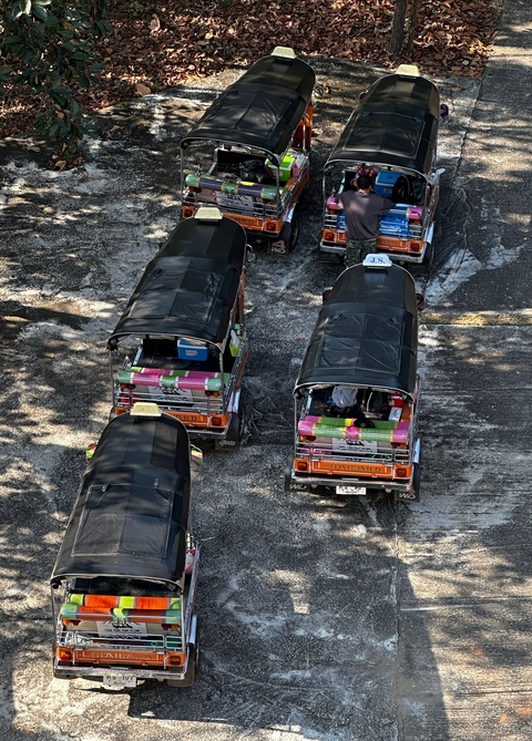Aerial view of Tuk Tuks parked on a street.