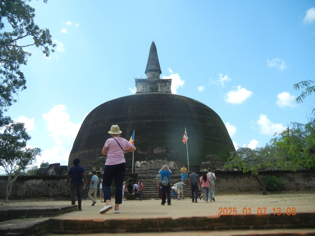 Tourists visiting a large ancient stupa.
